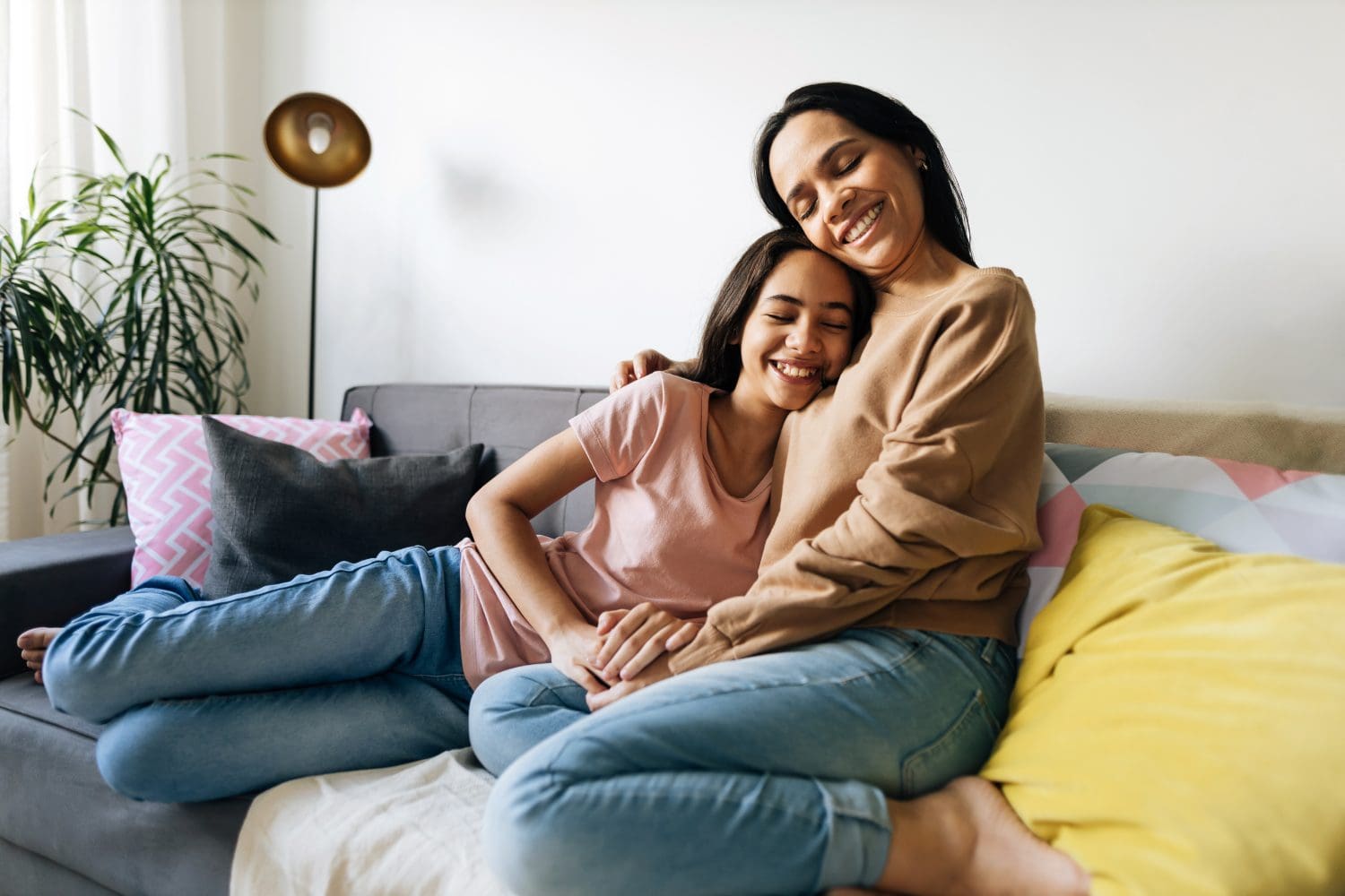 Mother hugging anxious teen to help co-regulate her emotions.