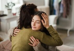Teen in reactive attachment disorder treatment program co-regulates with teen by hugging and practicing safe touch.
